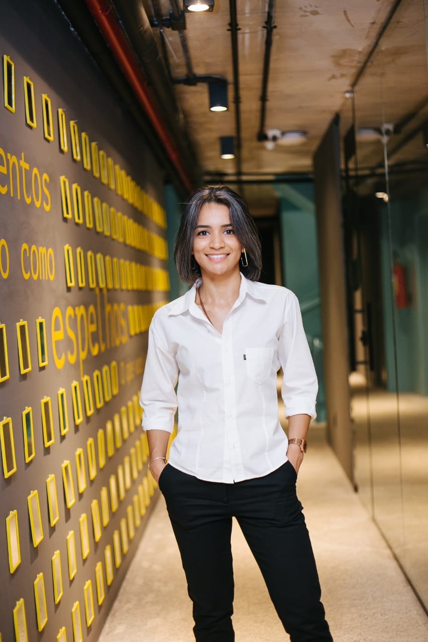 foto da proprietária em pé de camisa branca